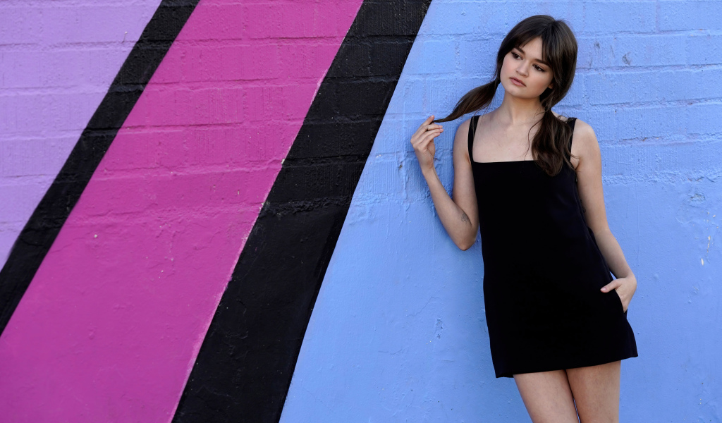 Милая девушка актриса Сиэра Браво у разноцветной стены