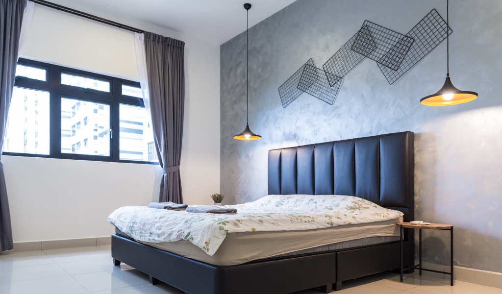 Пустая спальная комната с большой кроватью у окна 