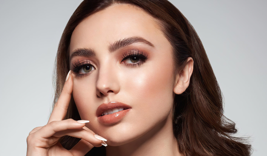 Лицо актрисы Пейтон Лист на сером фоне крупным планом