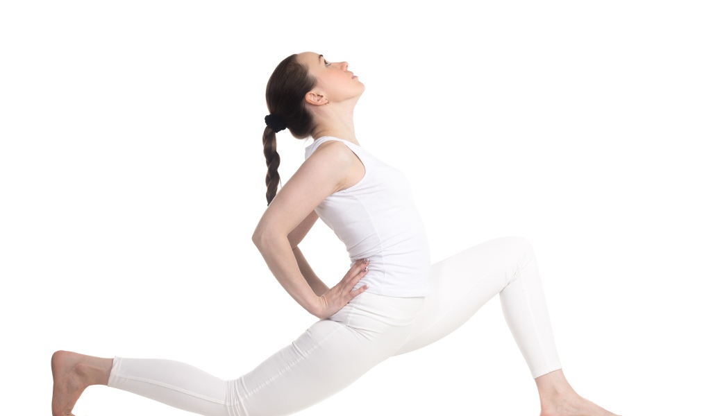 Девушка в белом костюме делает растяжку