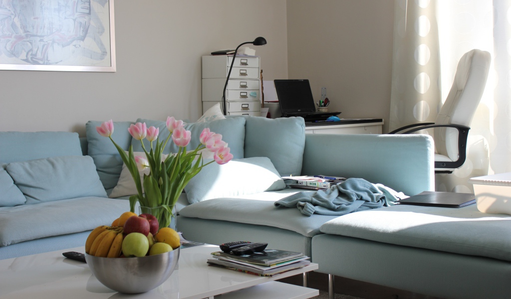 Большой серый диван в гостиной со столом 