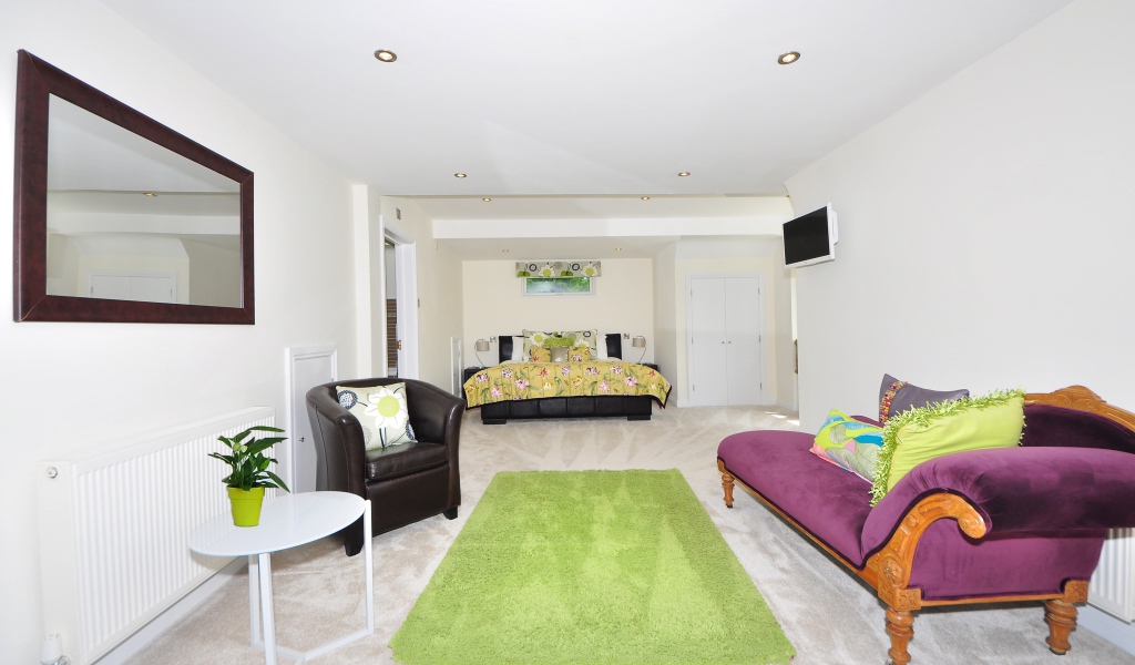 Большая гостиная с высокими белыми стенами и мебелью 