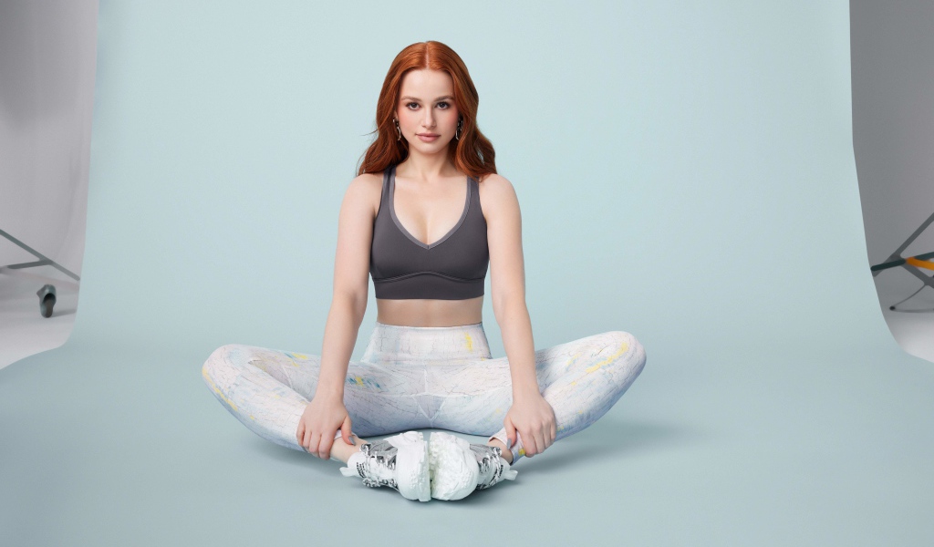 Рыжеволосая американская актриса Мэделин Петш сидит в позе лотоса