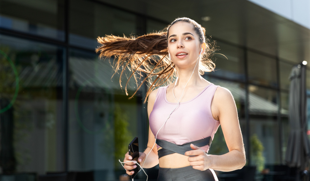 Спортивная девушка занимается бегом на улице