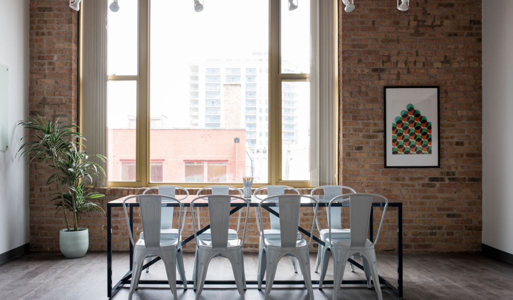 Стол с белыми стульями у большого окна на кухне 