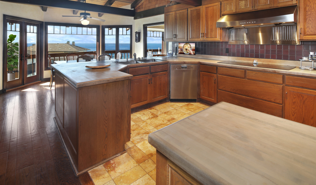 Деревянная мебель на кухне с окнами с видом на море