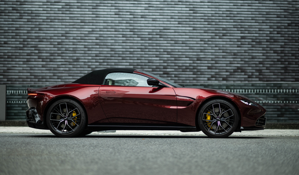 Red car Aston Martin Vantage Roadster 2023 on the background of the wall