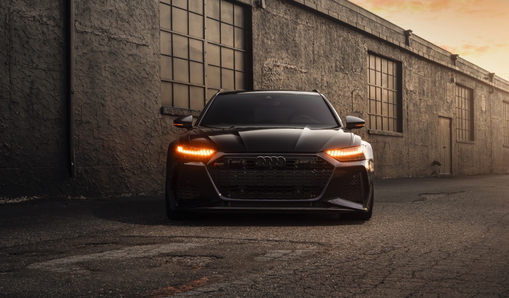 Черный автомобиль Audi RS7 у стены