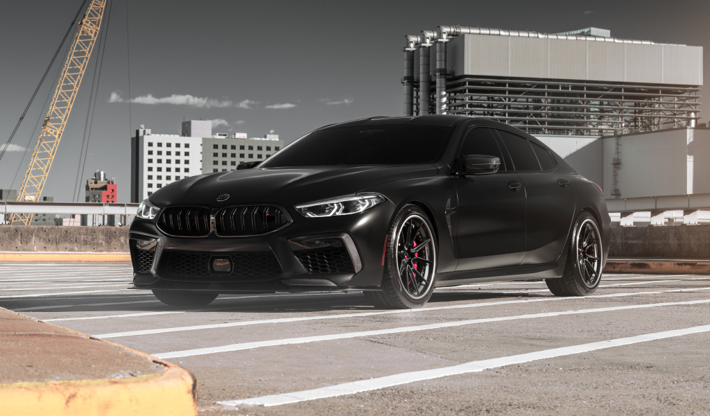 Черный автомобиль BMW M8 на стройке