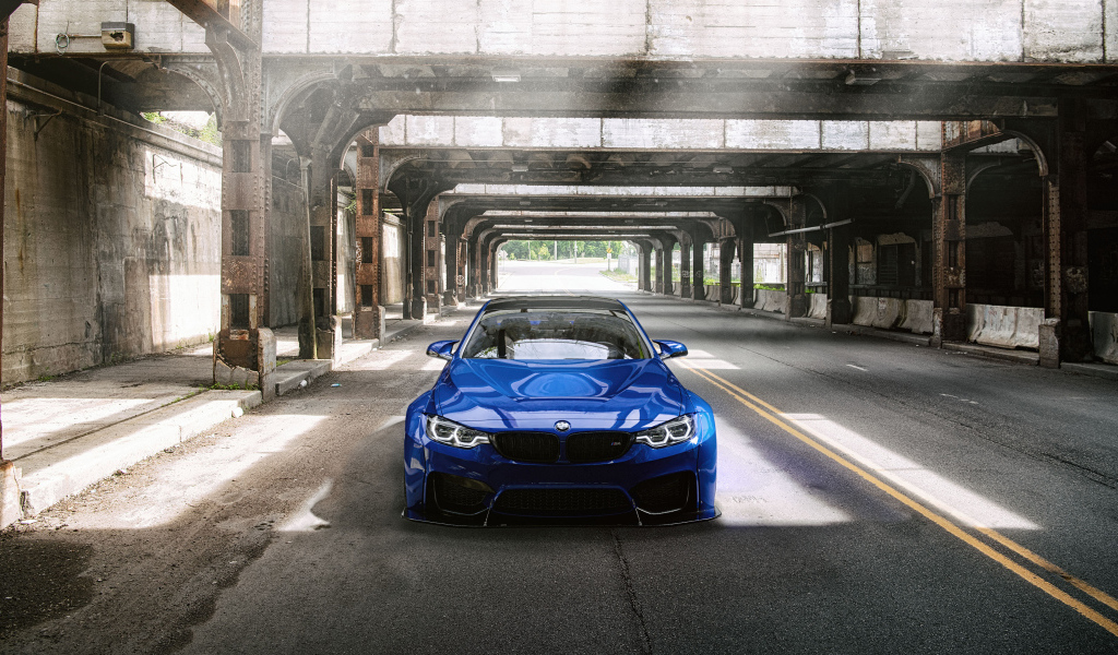 Синий автомобиль BMW M4 под мостом