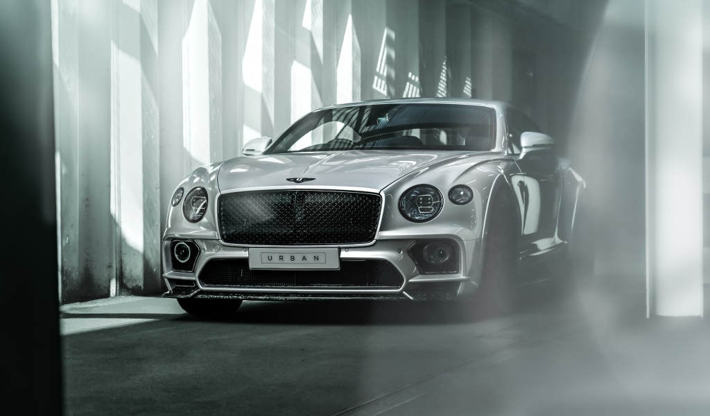 Серебристый автомобиль Bentley Continental GT в здании