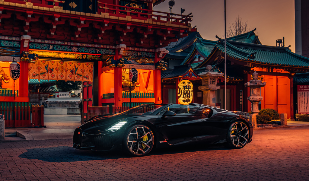 Черный спортивный автомобиль Bugatti W16 Mistral  у здания