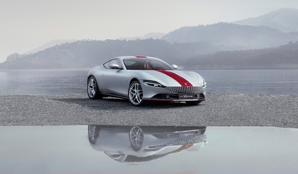 Автомобиль Ferrari Roma 30th Anniversary 2023  отражается в воде