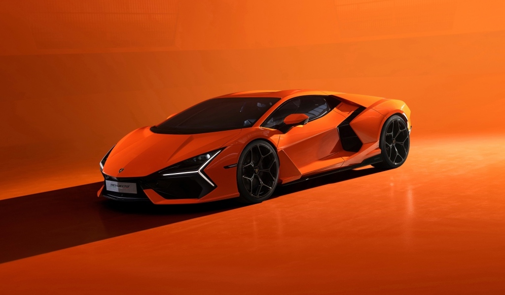 Автомобиль Lamborghini Revuelto 2023 года на оранжевом фоне