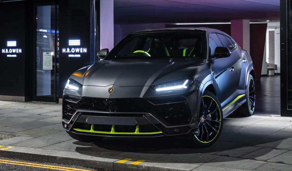 Серебристый Lamborghini Urus с включенными фарами
