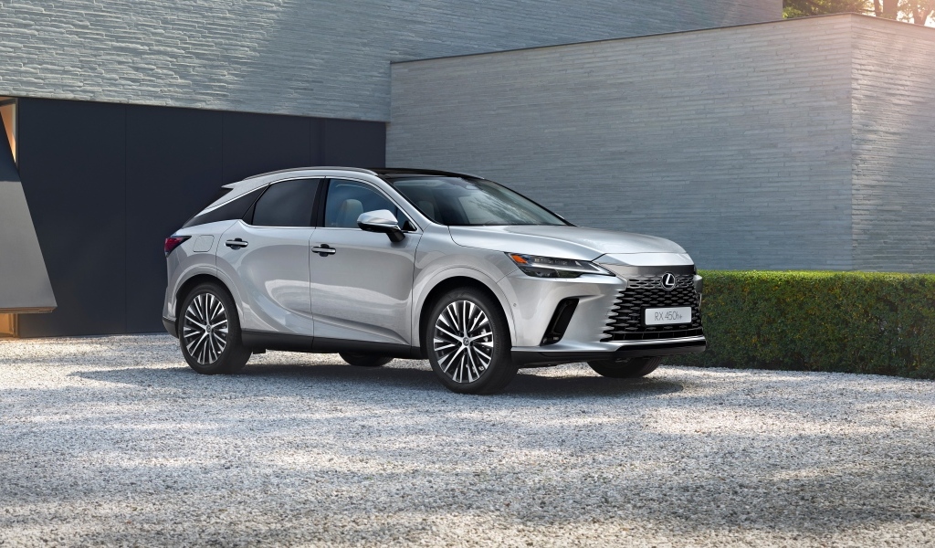Серебристый внедорожник Lexus RX 450h+ у здания