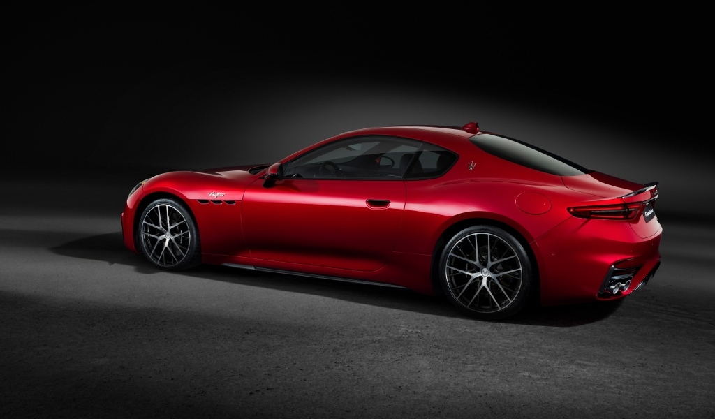 Красный автомобиль Maserati GranTurismo Trofeo 2023 на сером фоне