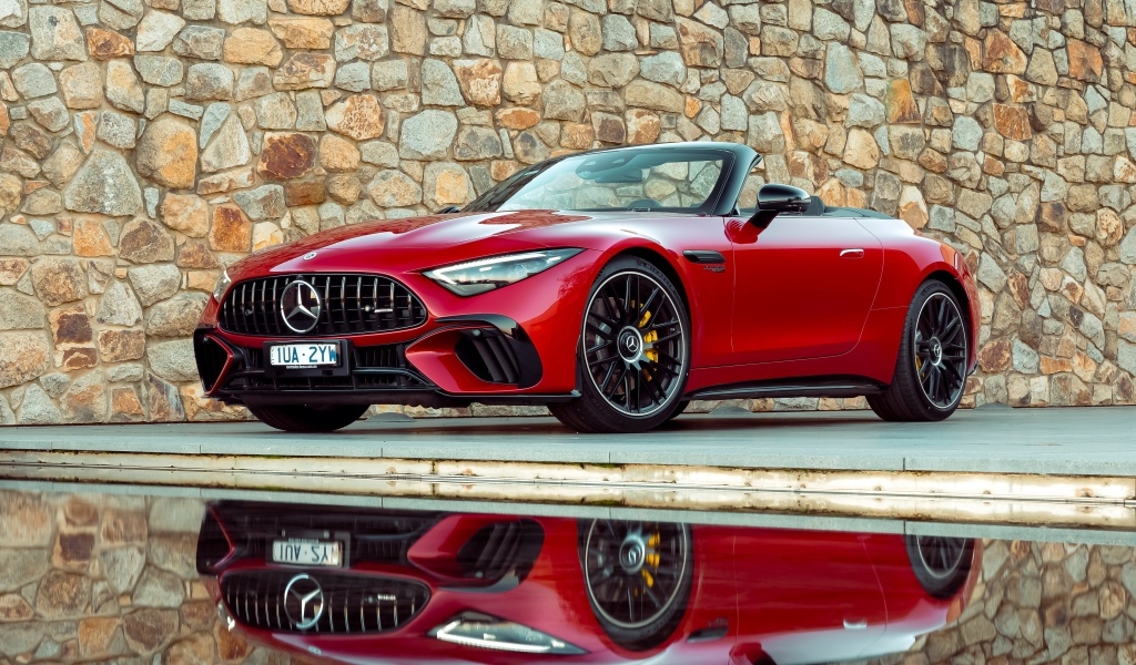 Красный Mercedes-AMG SL 63 4MATIC+ 2023 года на фоне стены