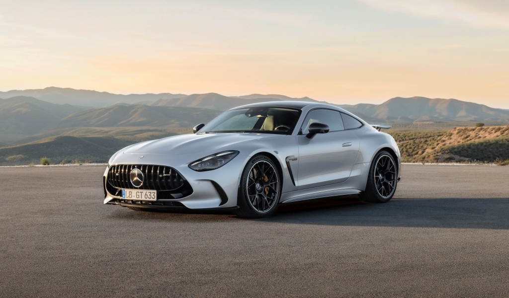 Серебристый автомобиль Mercedes-AMG GT 63 4MATIC+ 2023 года на фоне гор