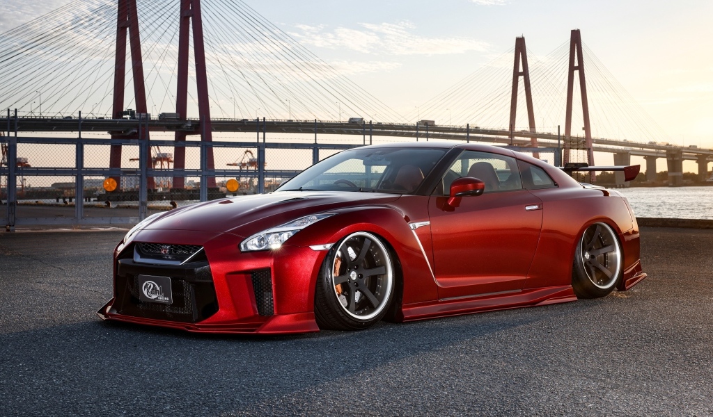 Красный автомобиль Nissan GTR 35R на фоне моста