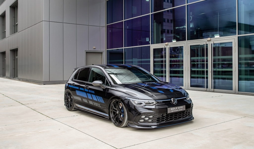 Черный автомобиль Volkswagen Golf GTE Meteora  у здания
