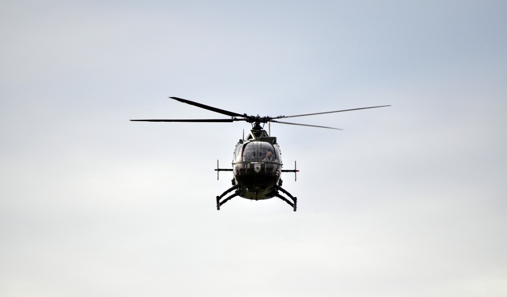 Big black helicopter flies in the sky