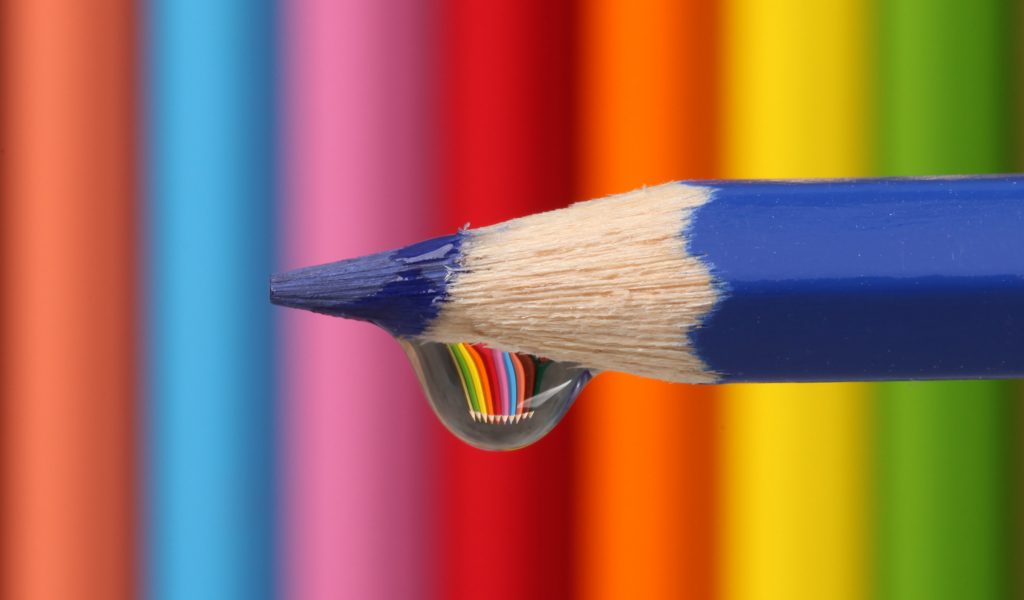 Капля воды стекает с синего карандаша