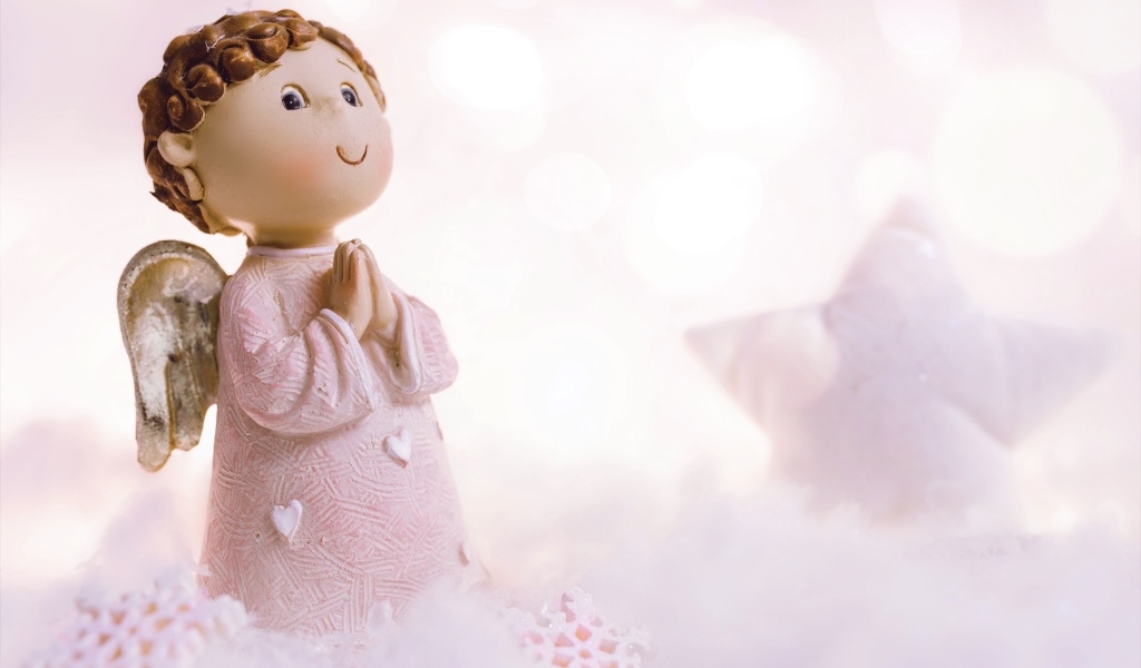 Маленькая статуэтка ангела стоит на снегу