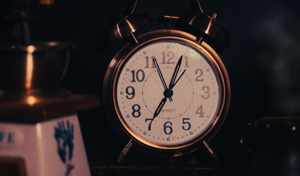 Большой будильник показывает семь часов