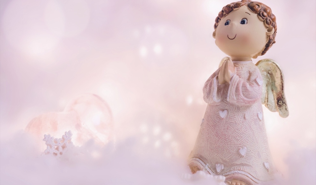 Статуэтка ангела на розовом фоне