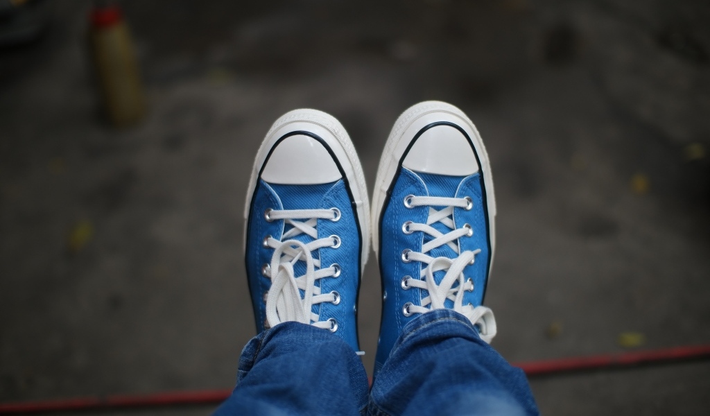 Кеды на ногах в джинсах