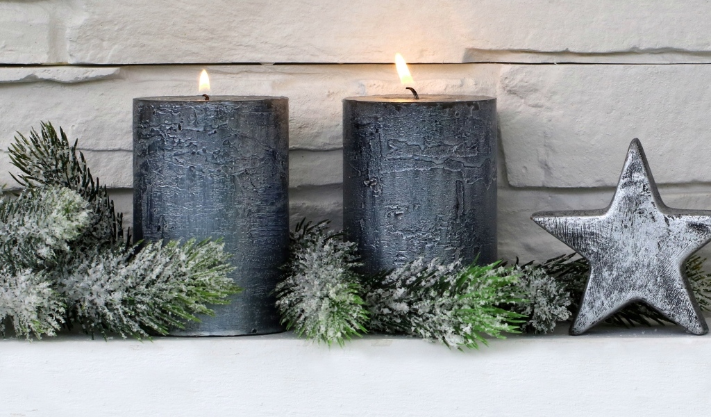 Две большие зажженные свечи у стены