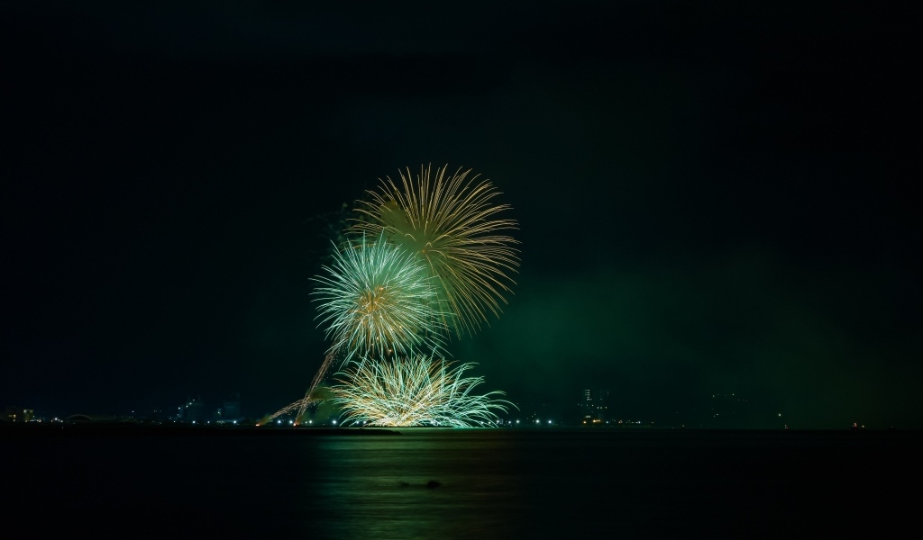 Вид с воды на красивые искры салюта