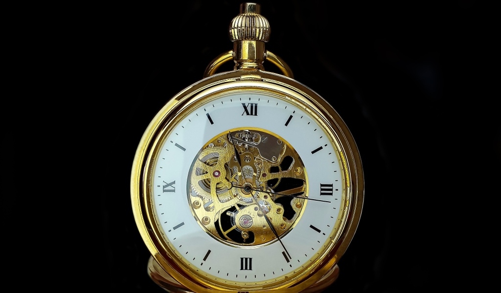 Старинные золотые карманные часы на черном фоне