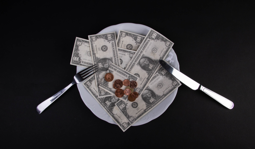 Тарелка с долларами на черном фоне