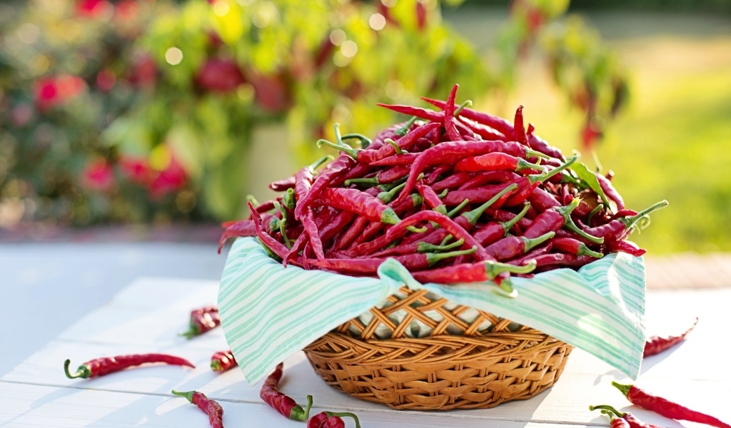 Много жгучего красного перца в корзине на столе