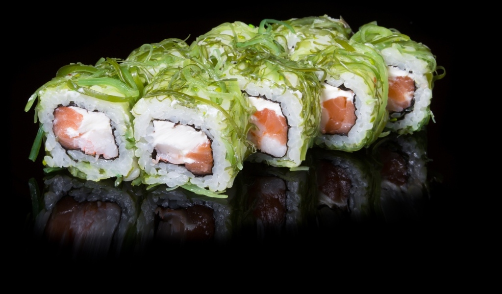 Аппетитные роллы с рыбой на черном фоне