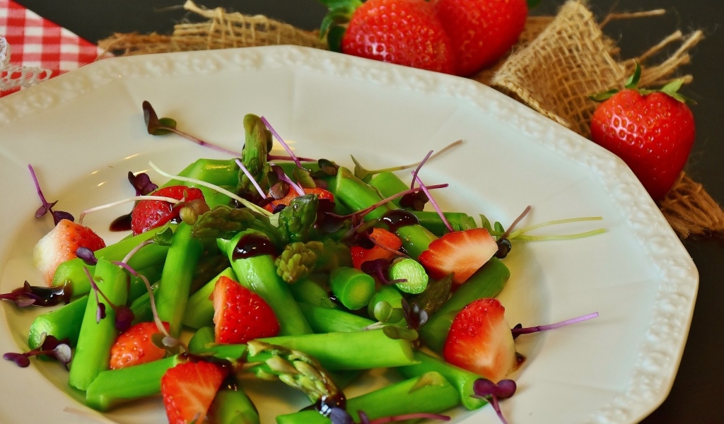 Спаржа в тарелке с клубникой