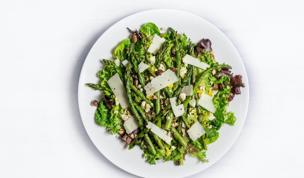Спаржа на белой тарелке с сыром