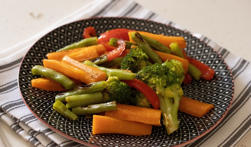 Запеченные овощи на красивой тарелке на столе