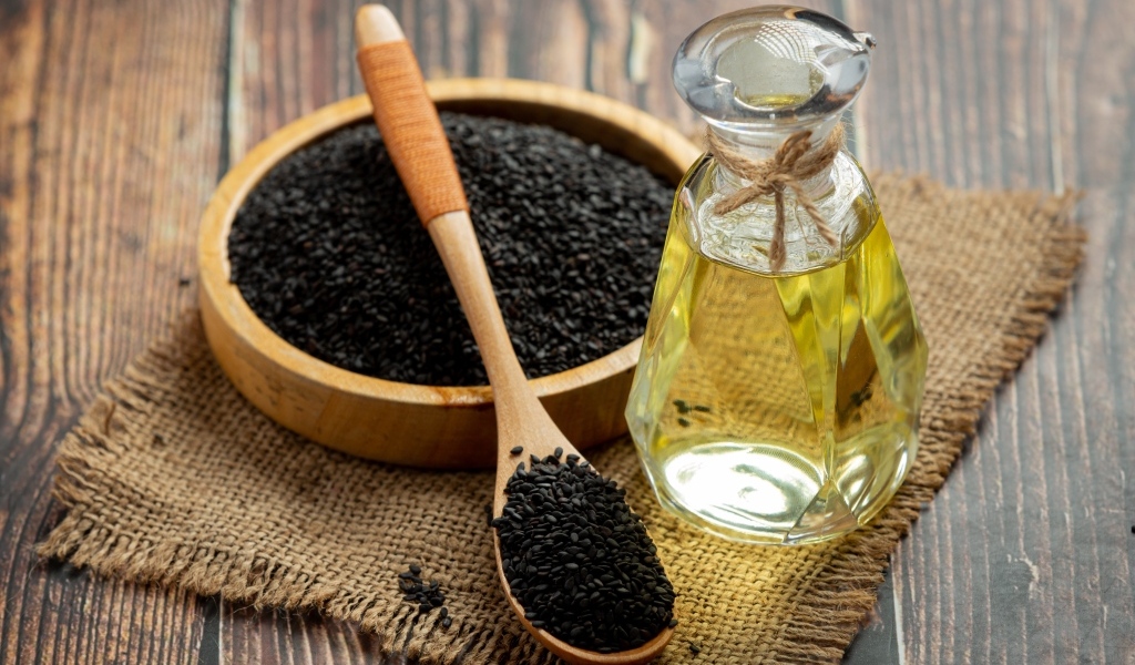 Черные семена на столе с маслом