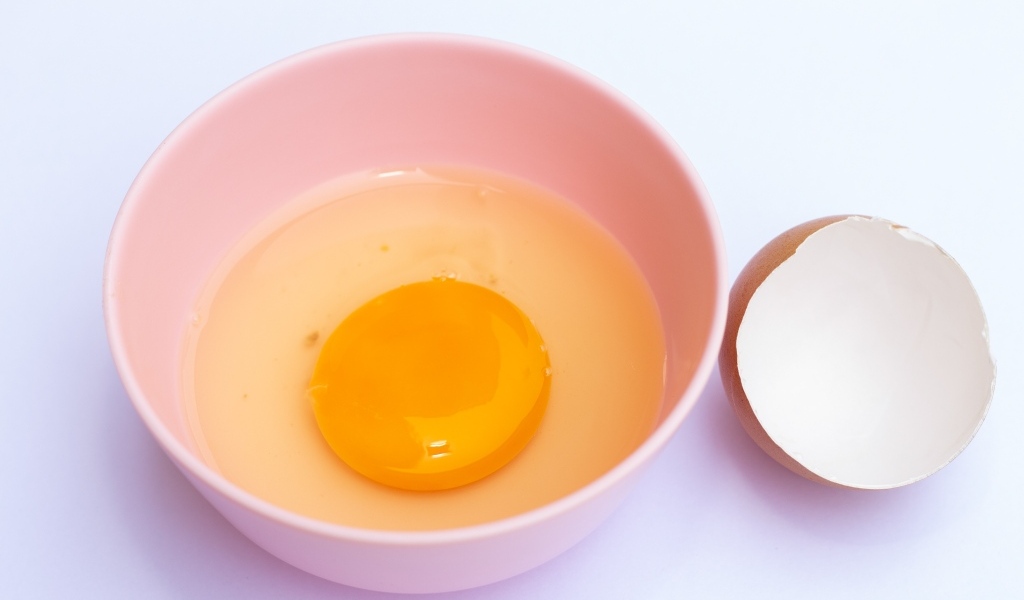 Разбитое яйцо на столе со скорлупой