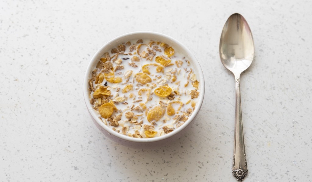 Хлопья с молоком в тарелке на завтрак