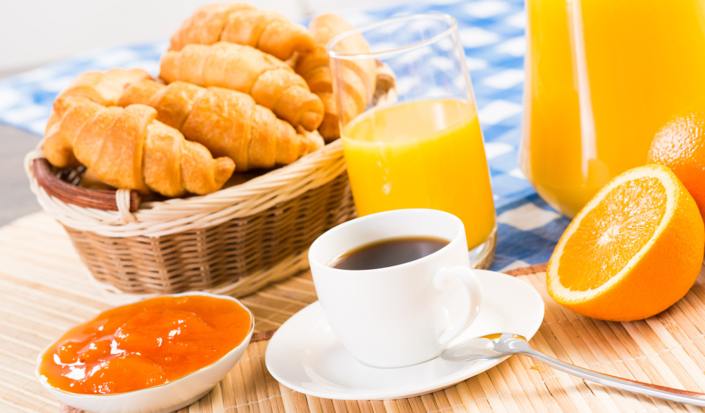 Кофе с круассанами и соком на столе на завтрак