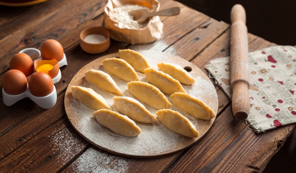 Вареники на столе  с яйцами и мукой