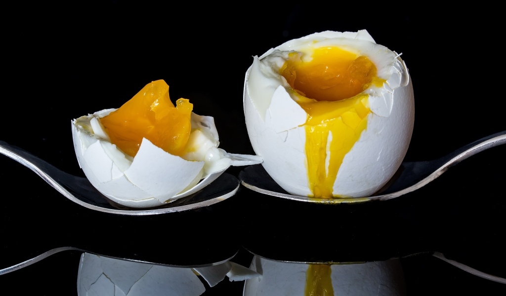 Яйцо с жидким желтком на черном фоне