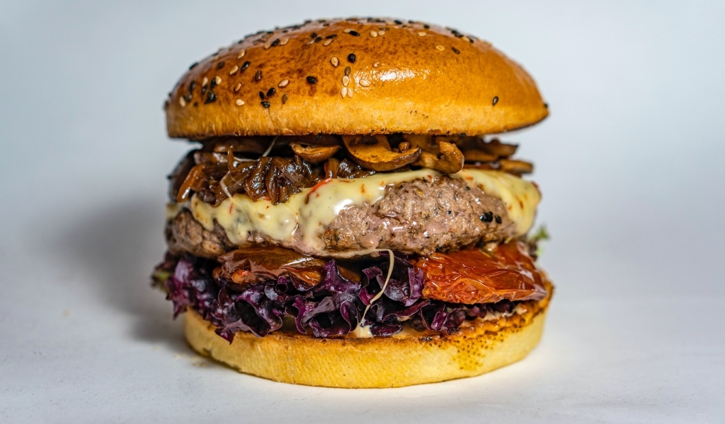 Ароматный сочный гамбургер на сером фоне крупным планом