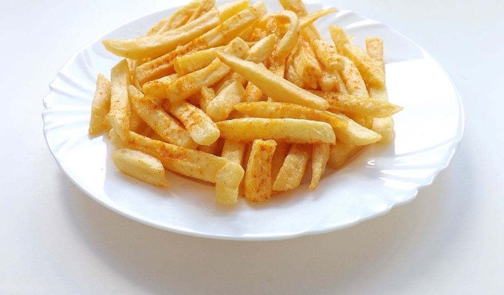 Картофель фри на большой белой тарелке