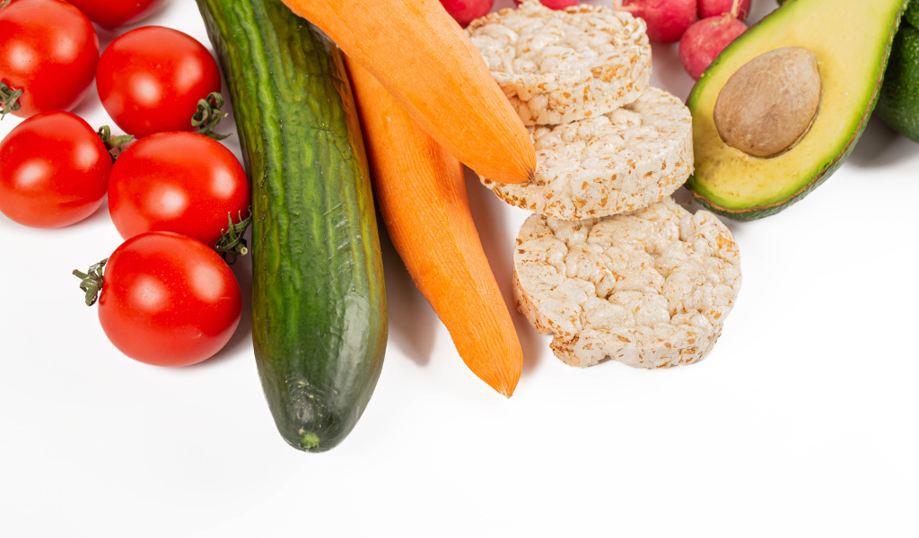 Свежие аппетитные овощи и хлопья на белом фоне