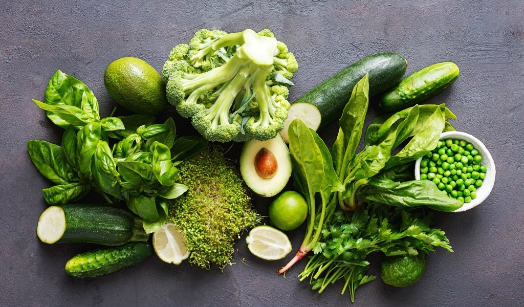 Свежие зеленые овощи на сером столе